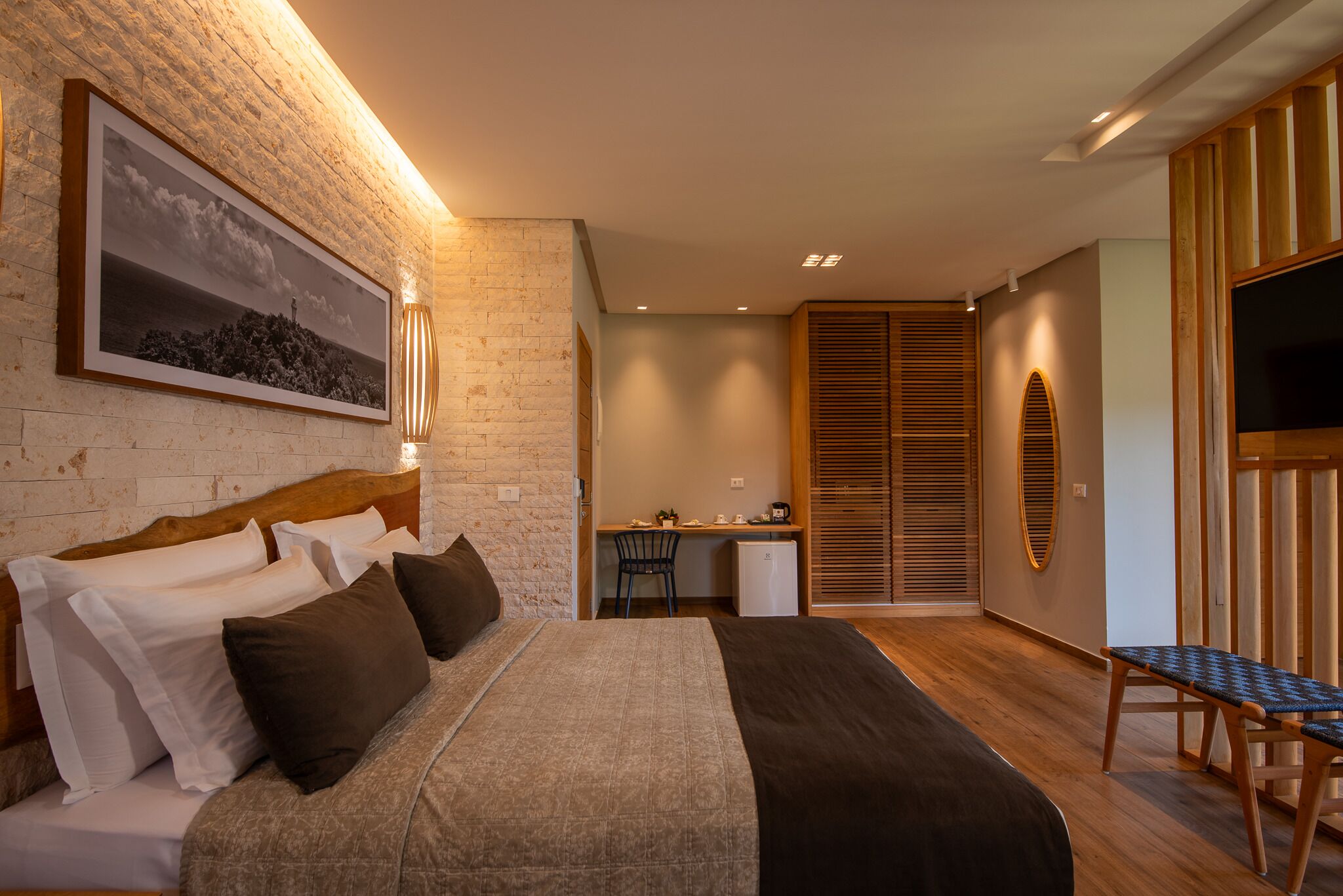 Un dormitorio moderno con una cama grande, un escritorio y un televisor.