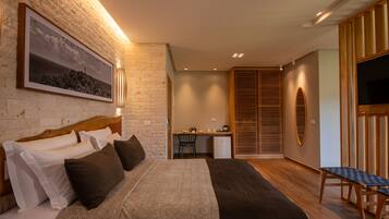 Un dormitorio moderno con una cama grande, un escritorio y un televisor.