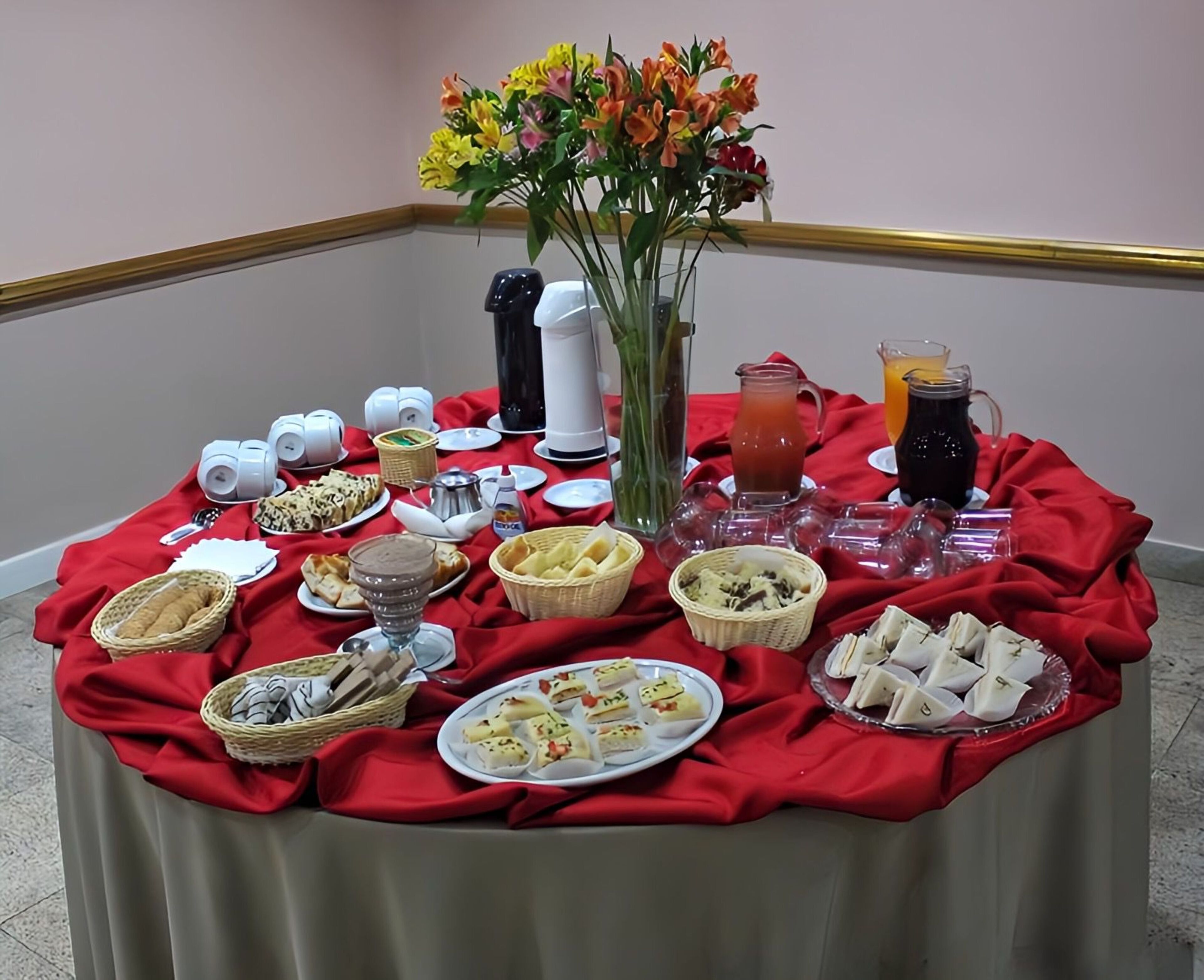 Une table de buffet garnie de divers plats, de boissons et d’un vase rempli de fleurs.