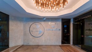A hotel lobby with a modern design, featuring a large sign reading "Centro de Convencoes" and a map of the Americas. - Hotel Pan Americano (São Paulo)