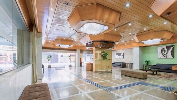 A spacious lobby with a modern design, featuring a large seating area, a reception desk, and a large window providing a view of the outside. - Hotel Pan Americano (São Paulo)