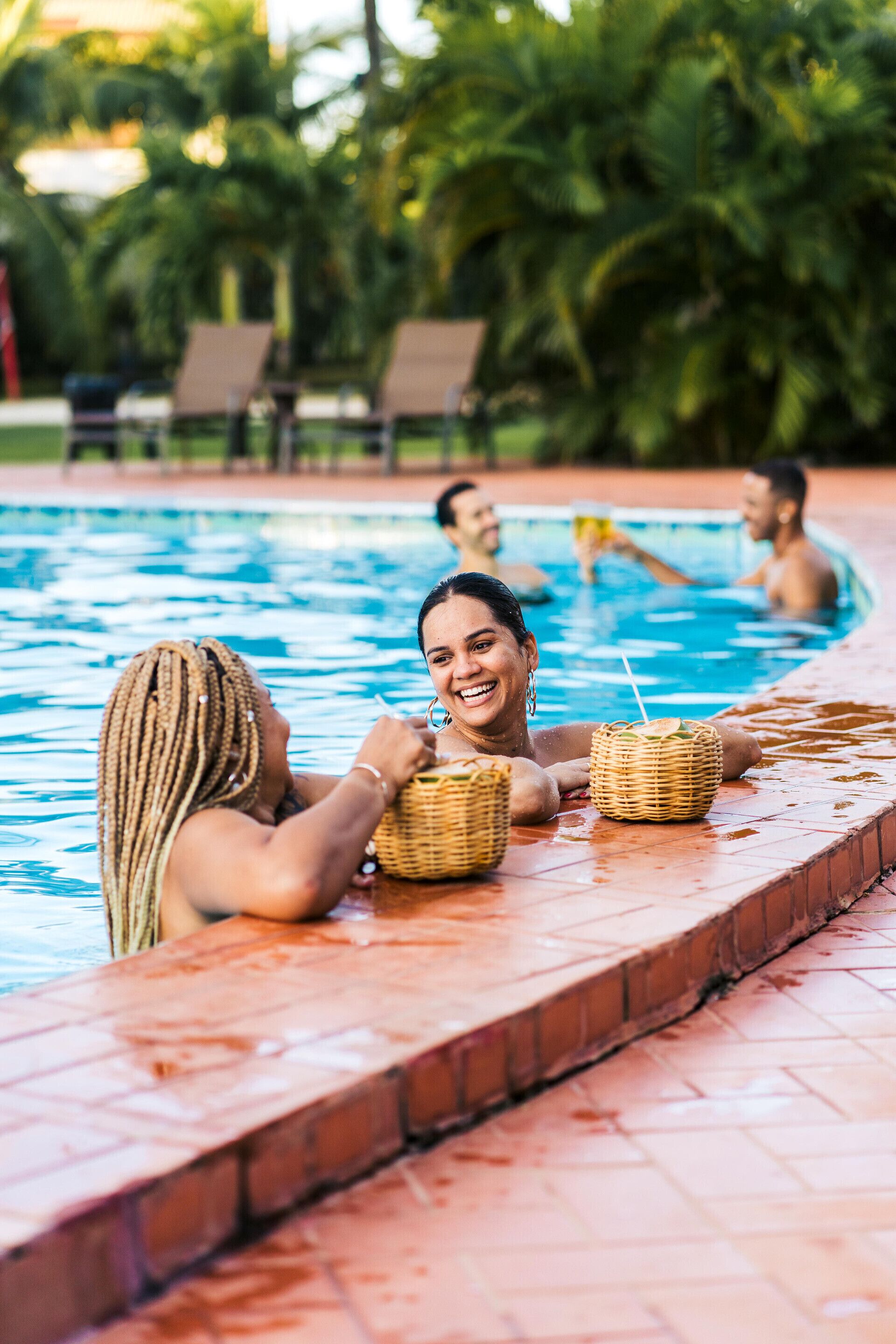 A swimming pool with lounge chairs and a brick border.