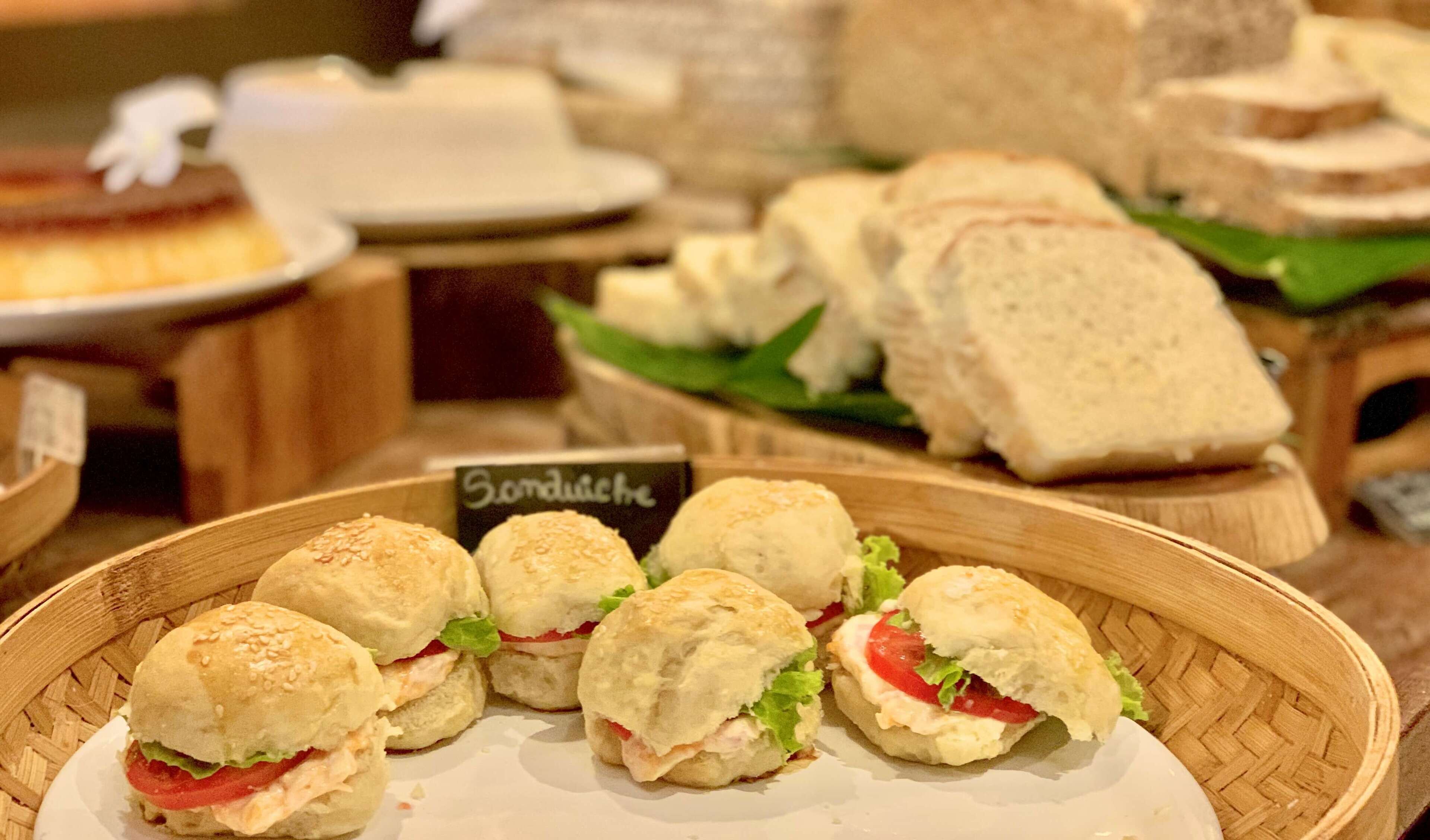 Ein Buffet mit verschiedenen Sandwiches und einem Schild mit der Aufschrift 'Sandwiches'.
