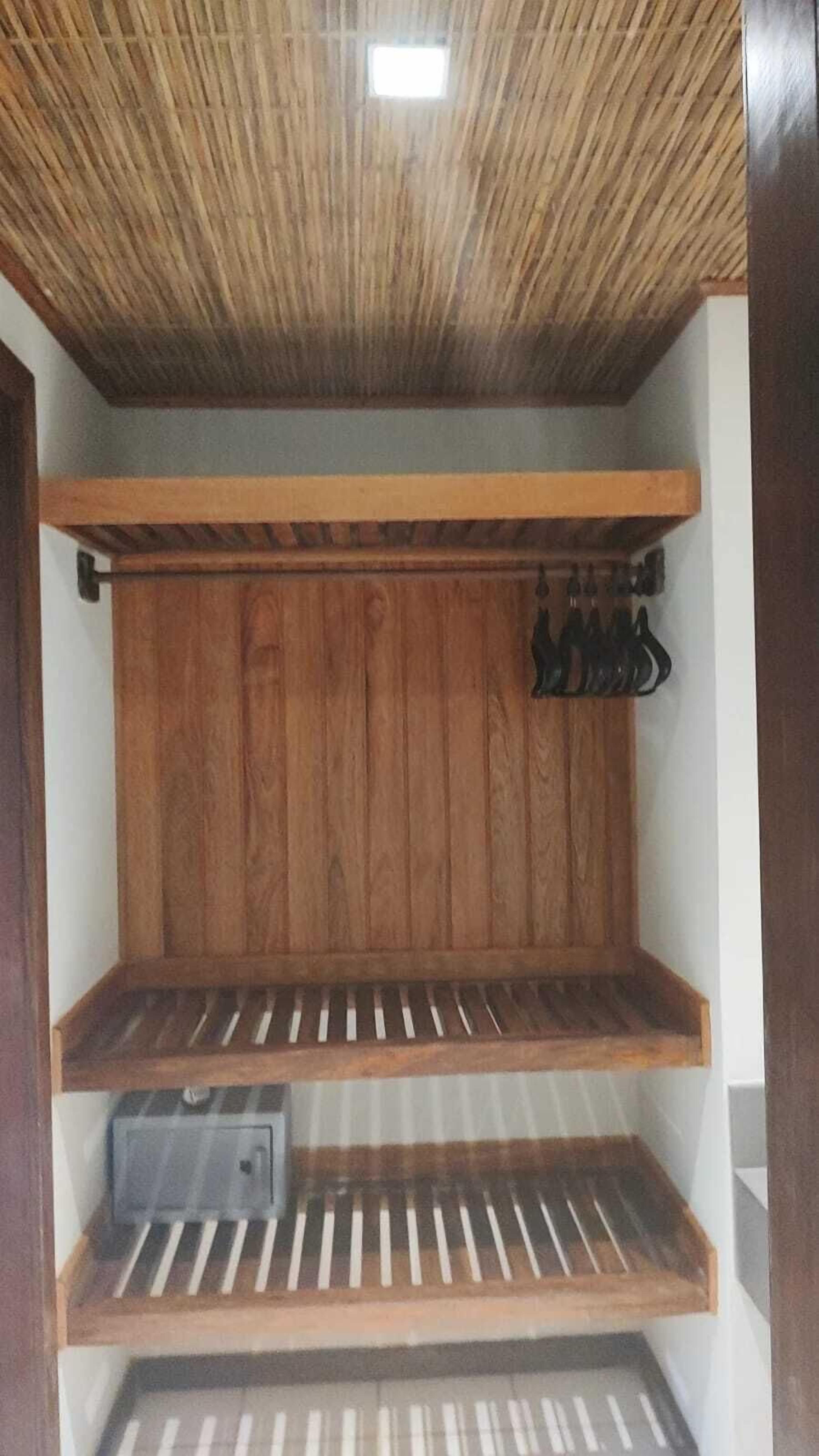 A wooden closet with shelves and a hanging rod.