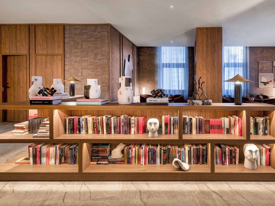 Eine moderne Bibliothek mit Holzbögen, einem Marmorboden und einem großen Fenster mit hellem Tageslicht.