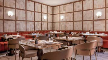 A restaurant with booths and tables, featuring a patterned wall and recessed lighting.