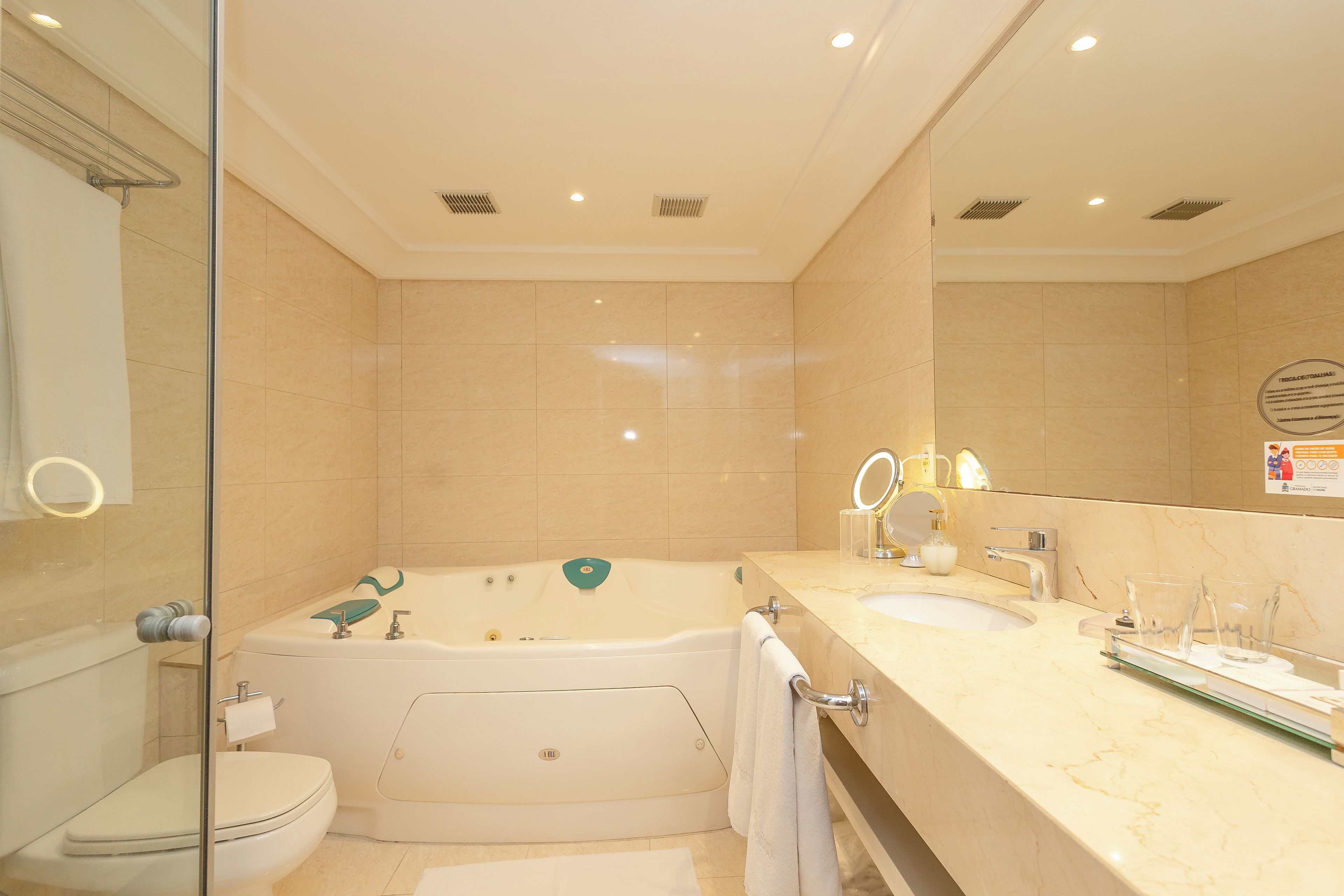 A modern bathroom with a bathtub, toilet, and vanity with a mirror.