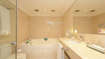 A modern bathroom with a bathtub, toilet, and vanity with a mirror.