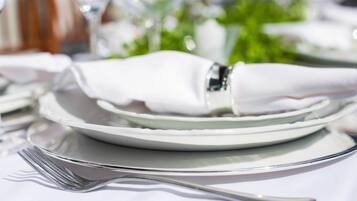 A neatly arranged dining table with a folded white napkin, a fork, and a plate.
