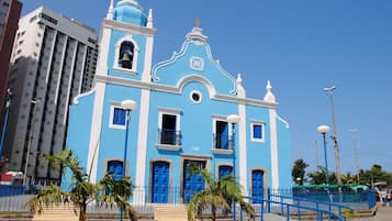 Une église bleue avec un clocher, des portes bleues et une horloge.