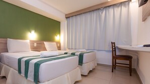 A hotel room with two beds, a desk, and a chair. - Rede Andrade Vela Branca (Recife)