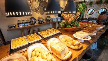 Un bufé con diversos alimentos, incluyendo panadería y bollería, además de detalles decorativos en la pared.