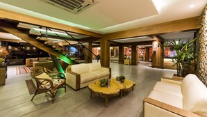 A spacious lobby with a staircase, seating areas, and a staircase with a green-lit handrail. - Natal Dunnas Hotel (Natal)