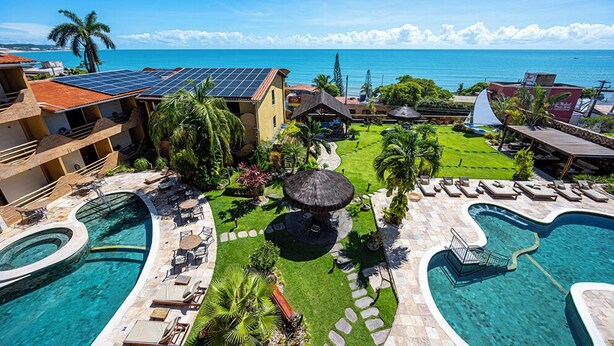 A resort with a pool, solar panels, and a view of the ocean. - Natal Dunnas Hotel (Natal)