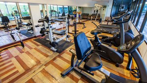 A gym with various exercise equipment, including treadmills, weight machines, and a rowing machine.