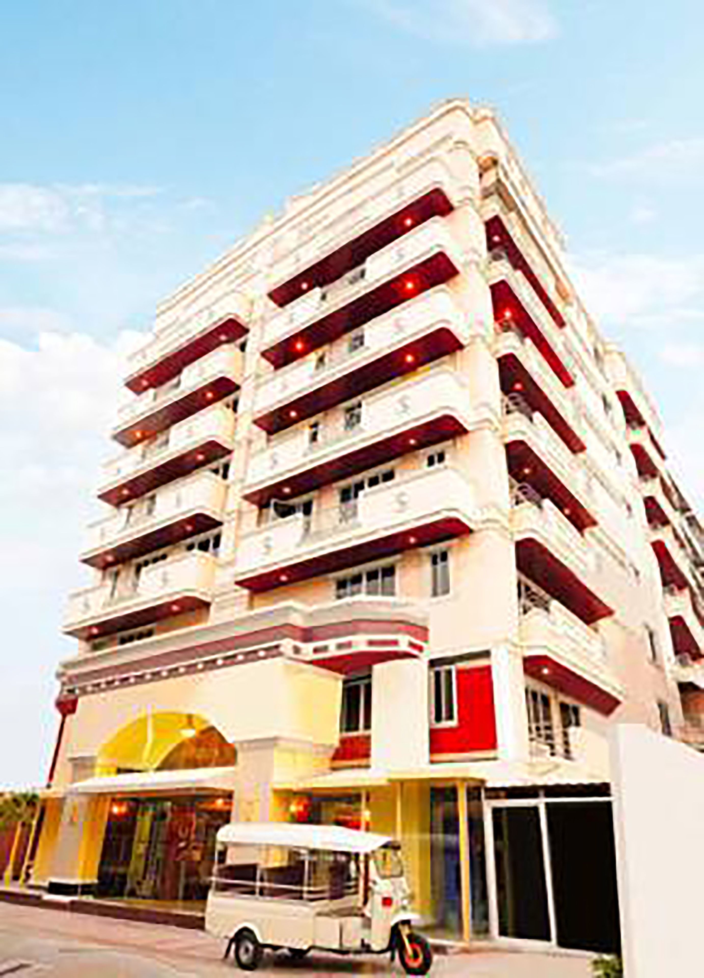 A multi-story hotel with balconies and a ground-level entrance.