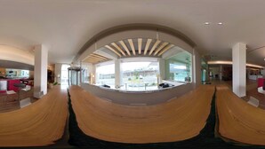 Un interior modern amb una bosa de fusta corbada, zones d'aixecament i una vista per una finestra gran.