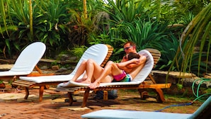 A poolside area with lounge chairs and a stone pathway. - Mansión de Chocolate (Granada)