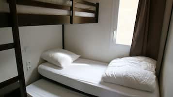 A bunk bed room with a window and curtains.