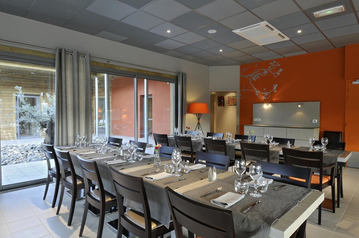 Un comedor con mesas dispuestas para una comida, un ventanal grande y un diseño de interiores moderno.