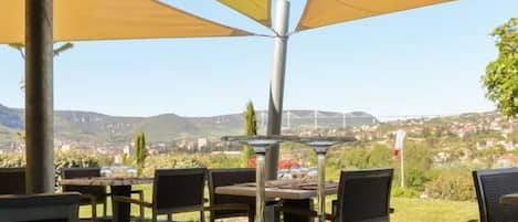 An outdoor dining area with tables, chairs, and umbrellas.