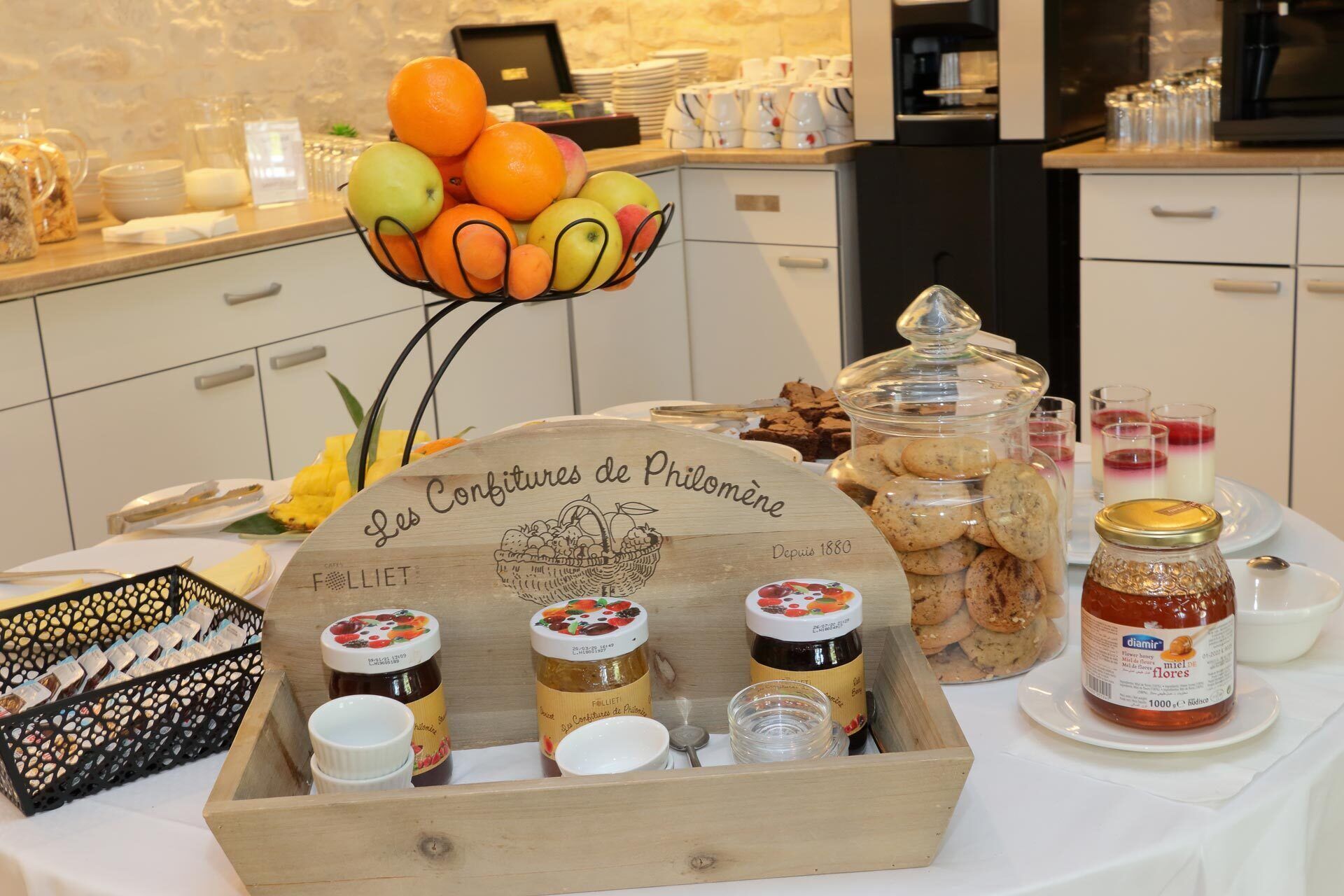 A breakfast buffet with various food items, including fruits, pastries, and condiments.