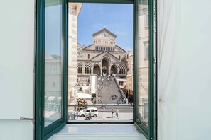 A view of a historic building with a prominent staircase leading to the entrance, surrounded by other buildings. - Albergo Sant'Andrea (Amalfi)