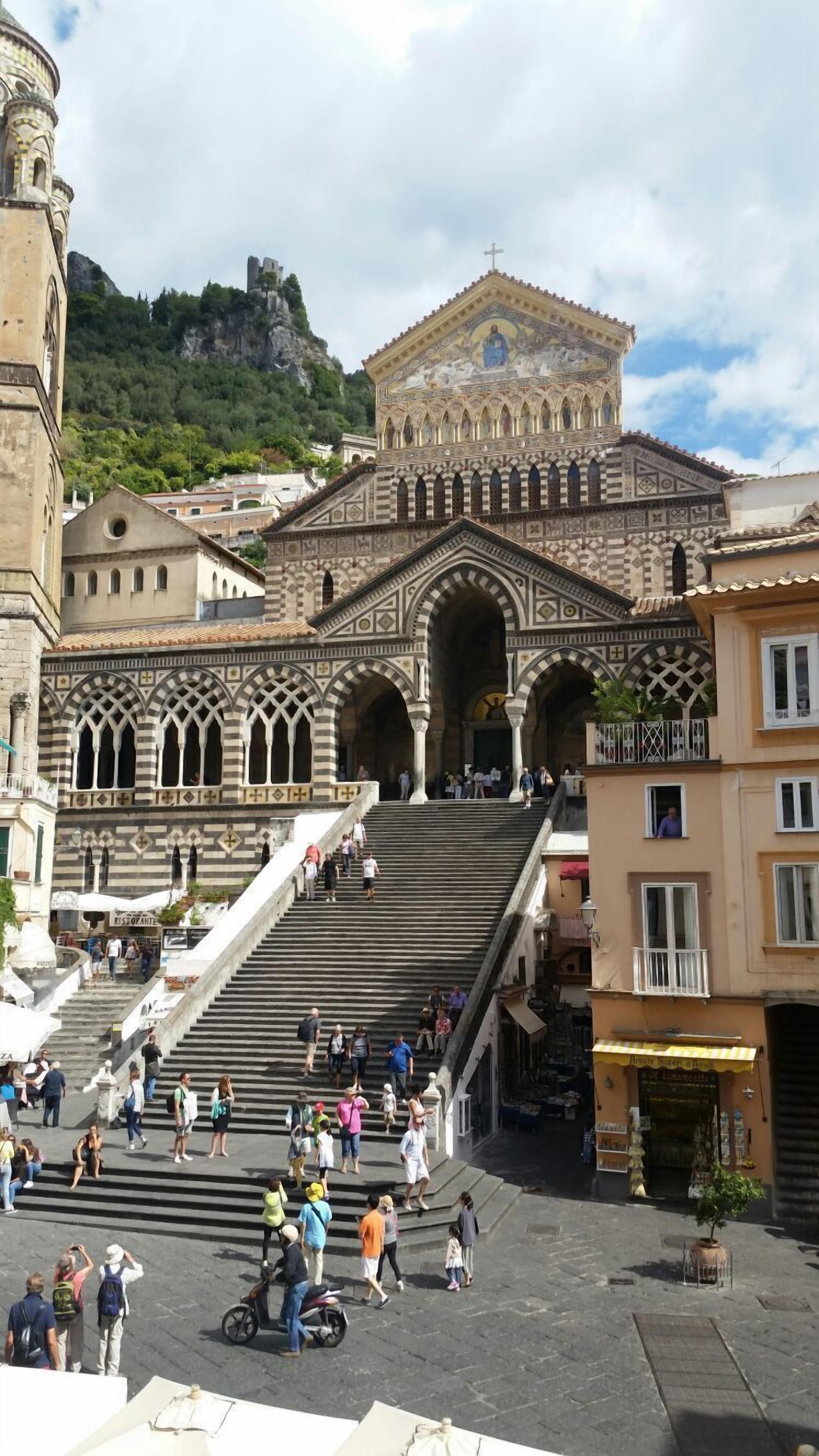 Un edificio histórico con una amplia escalera que conduce a una entrada ornamentada.