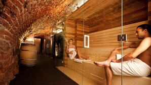 Uma sauna com bancos de madeira e divisória de vidro.