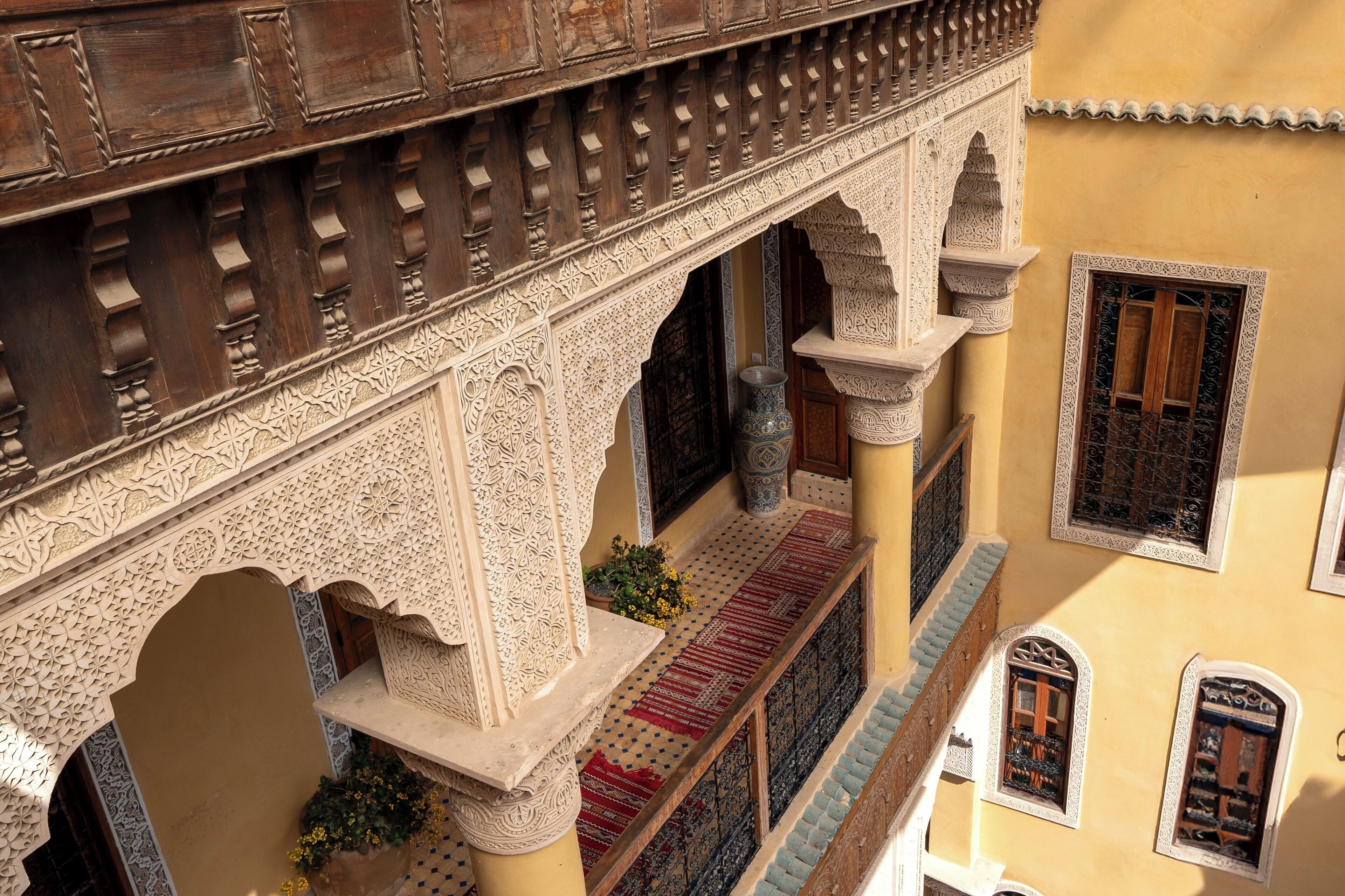 An ornate architectural corridor with intricate carvings and a tiled floor.