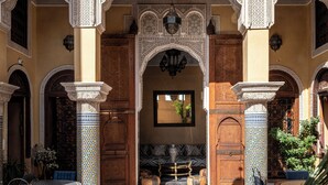 An interior courtyard with ornate arches, a central fountain, and seating areas.