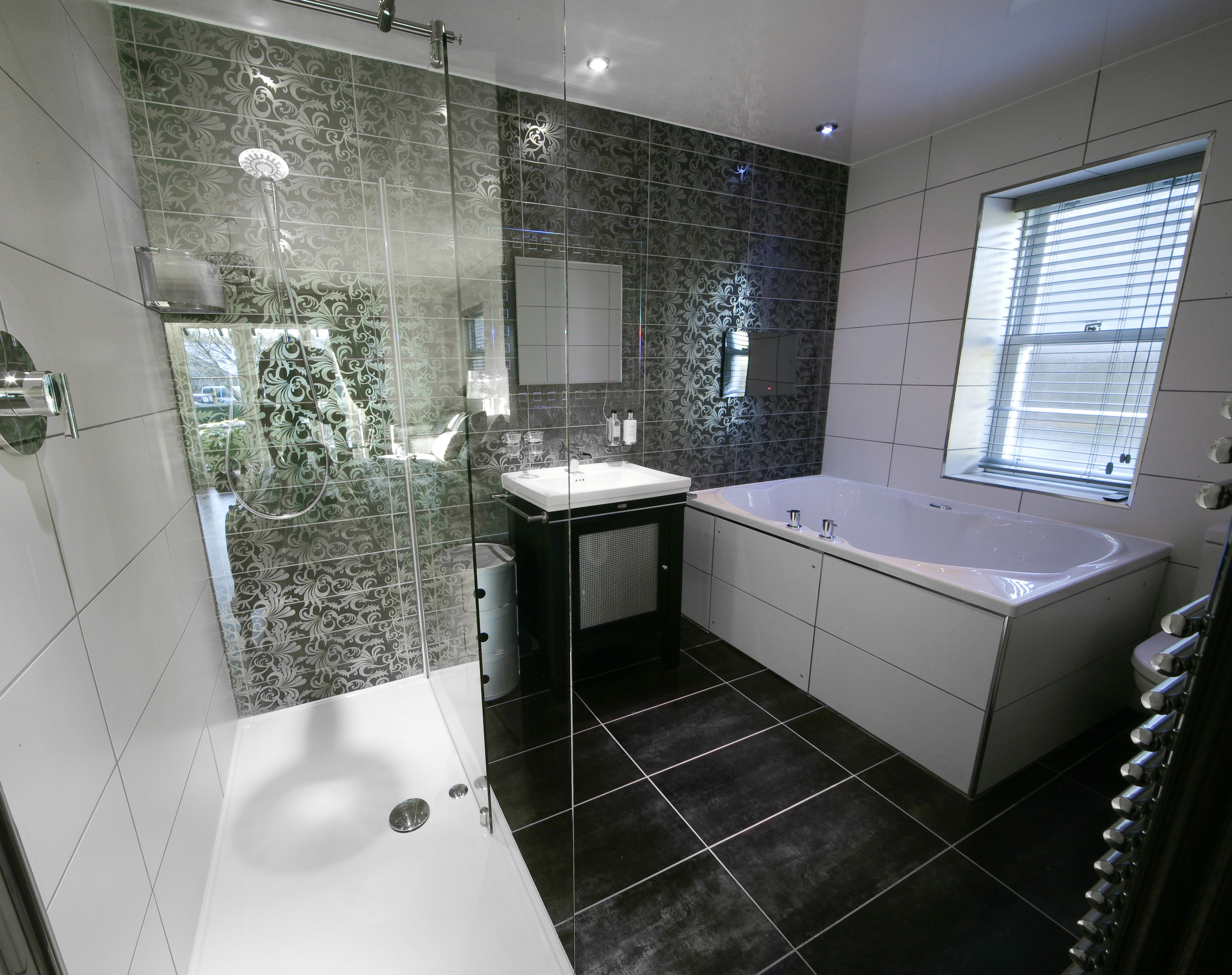 A modern bathroom with a glass-enclosed shower, a freestanding bathtub, and a vanity with a sink.