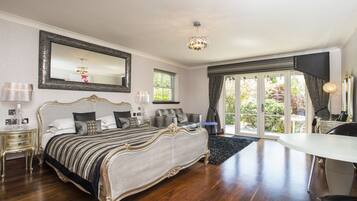 A spacious bedroom with a large bed, a dining table, and a balcony with a view.