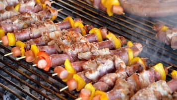 Brochetas de carne y verduras sobre una parrilla.