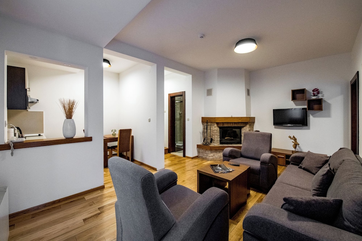 A modern living room with a fireplace, seating area, and a television.