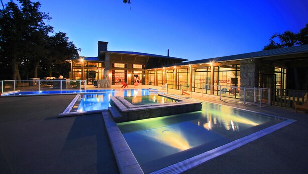 A modern building with a pool area at dusk. - Albirondack Park Camping Lodge and Spa (Albi)