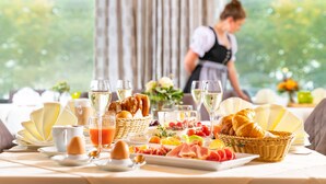 A breakfast buffet with various foods and drinks, including pastries, fruits, and a selection of cheeses. - Hanusel Hof (Weitnau)