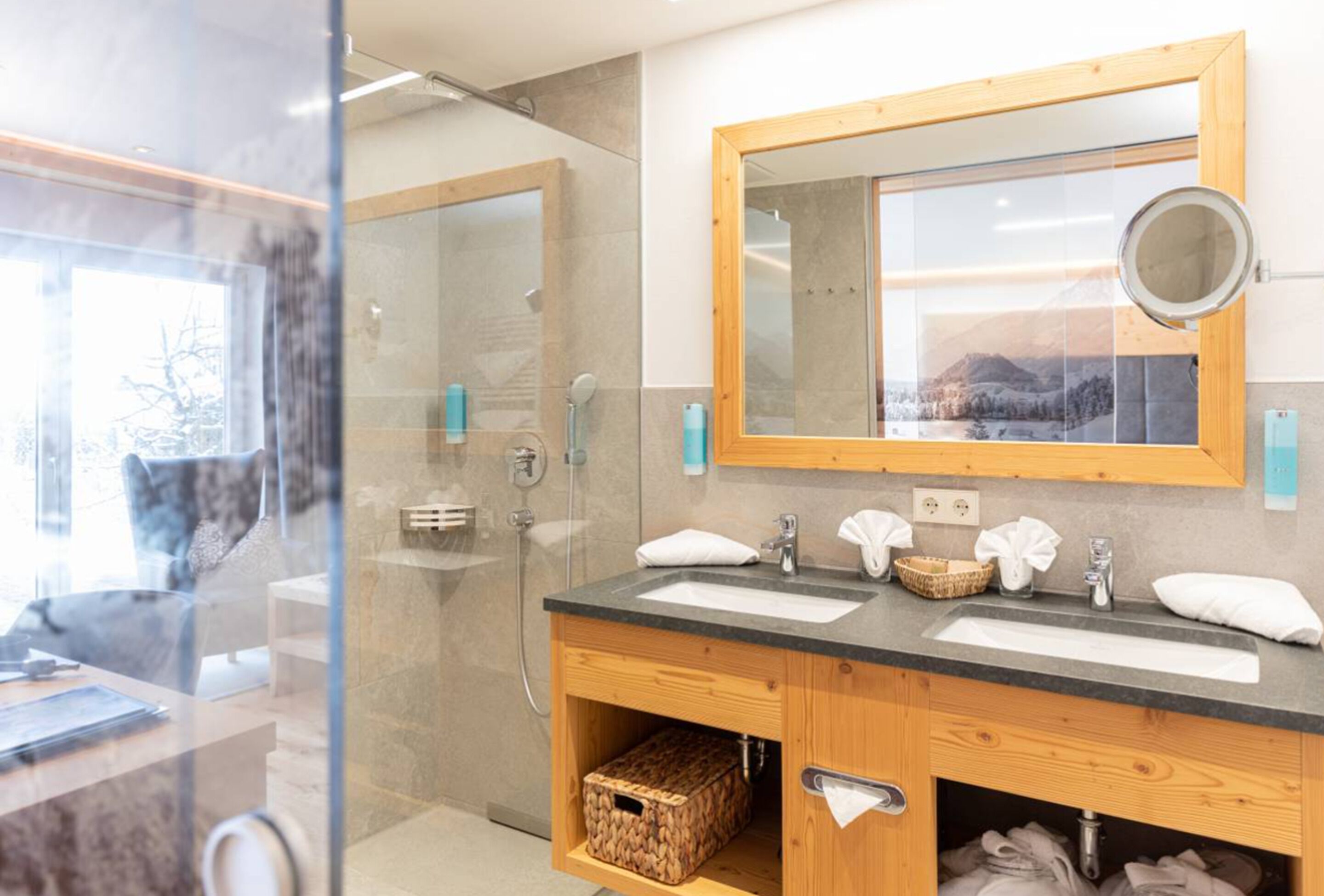 Un bagno moderno con due lavandini, uno specchio grande e una doccia.
