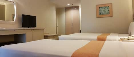 Habitación de hotel con dos camas, un escritorio con televisor, un armario y un cuadro en la pared.