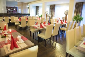 A restaurant with multiple tables set for dining, featuring red napkins and candles. - Hotel Rödelheimer Hof - Am Wasserturm (Frankfurt)