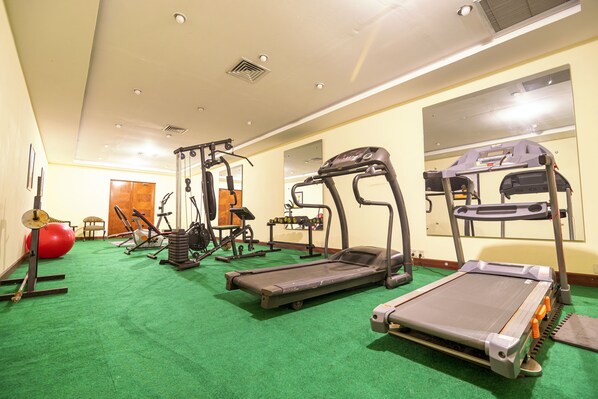 Un gimnasio con cintas de correr, pelotas de ejercicio y máquinas de pesas.