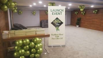 A room with a reception desk, a banner for a launch event, and green spherical decorations.