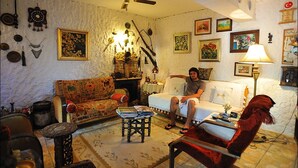 A cozy living room with a sofa, armchair, and a fireplace. - Nazhan Hotel - Boutique Class (Selçuk)