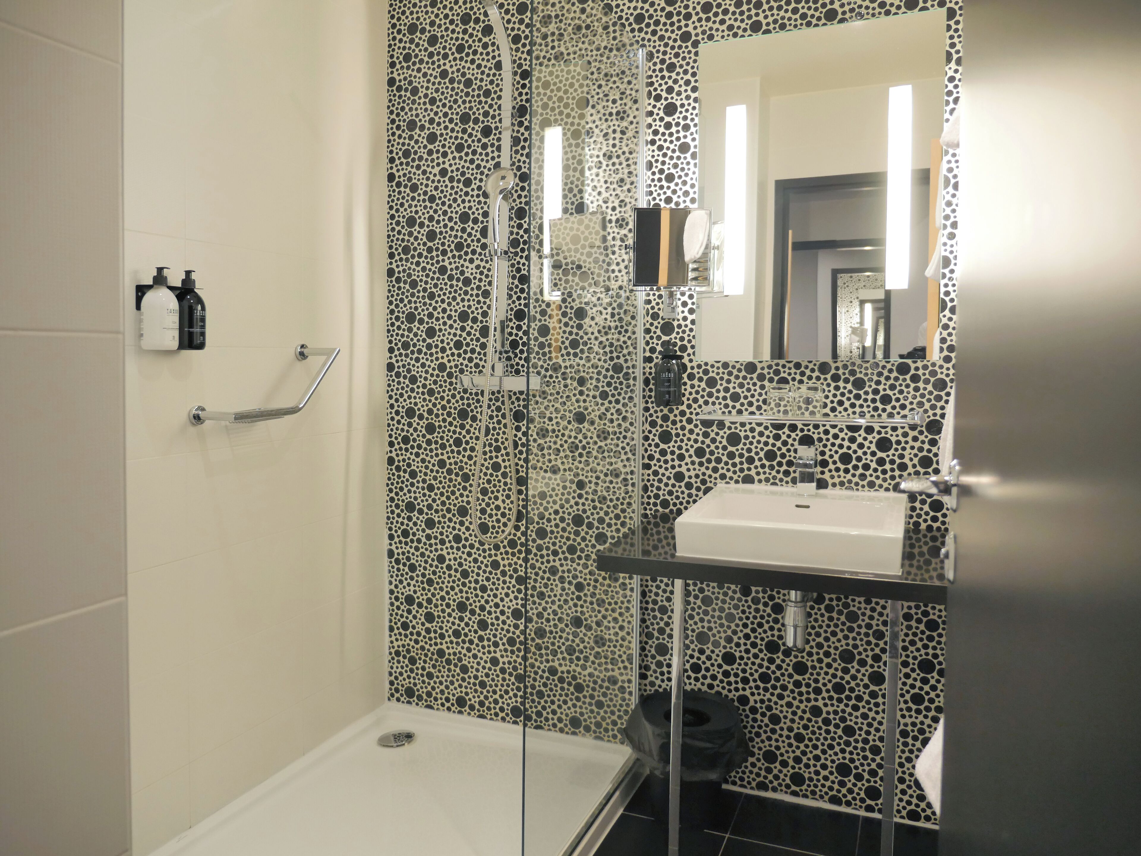 Un baño moderno con ducha, lavamanos e inodoro.