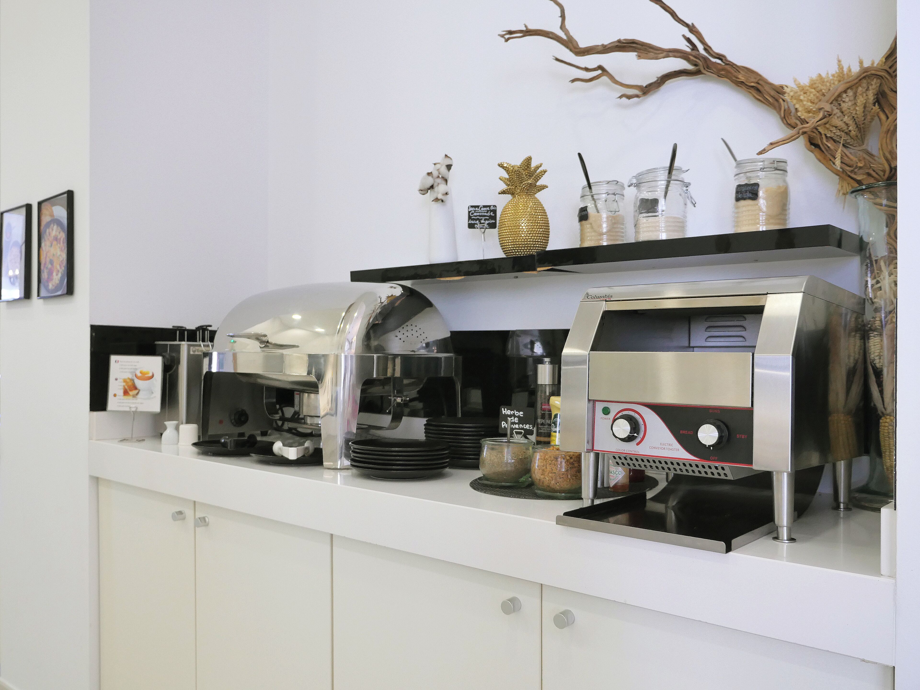 A coffee station with a coffee machine, a frosted glass coffee pot, and a menu board.