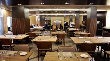 Un comedor amplio con múltiples mesas y sillas, asientos numerados y un diseño de interiores moderno.