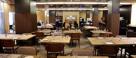 Un comedor amplio con múltiples mesas y sillas, asientos numerados y un diseño de interiores moderno.