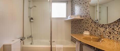 Ein Badezimmer mit Toilette, Badewanne, Waschbecken und Dusche.