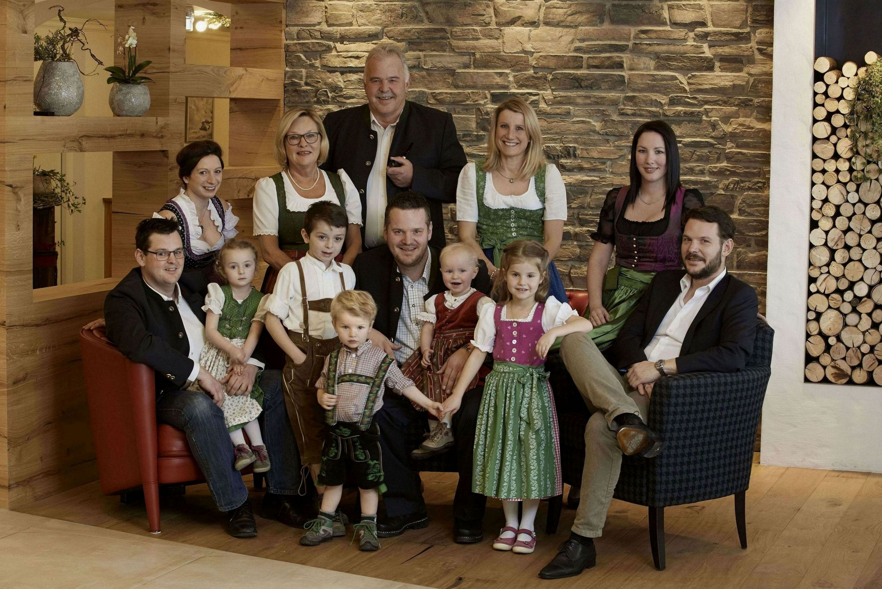 Ein Familienfoto in einem Zimmer mit Steinwand und Holzmöbeln.