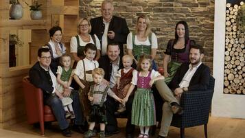 Ein Familienfoto in einem Zimmer mit Steinwand und Holzmöbeln.